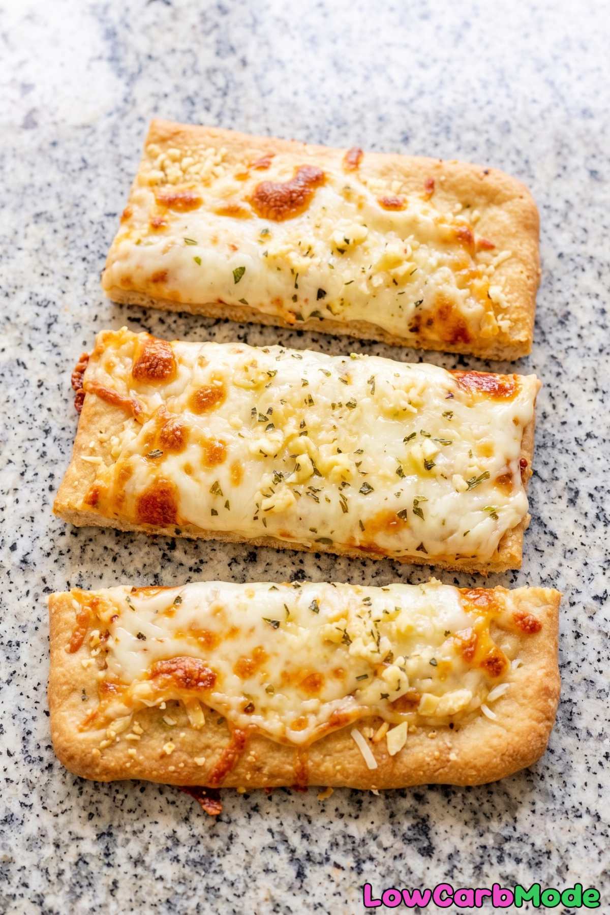 Warm keto cheesy breadsticks on a baking pan
